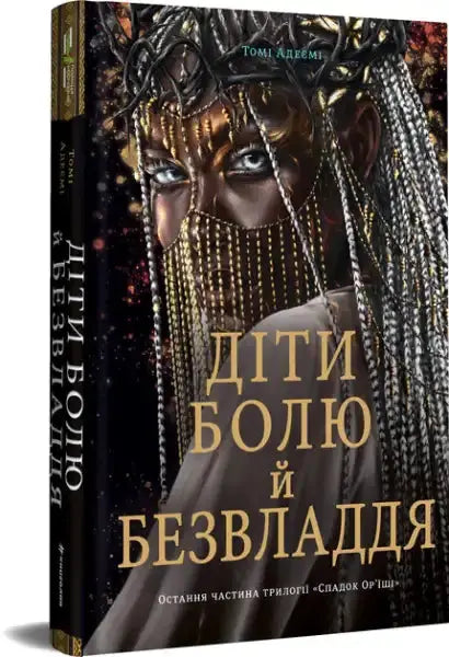 Children of Pain and Powerlessness book with vibrant cover featuring a person in gold and silver accessories, part of the orïshi trilogy by Tomi Adeyemi Children of Pain and Powerlessness book with vibrant cover featuring a person in gold and silver accessories, part of the orïshi trilogy by Tomi Adeyemi