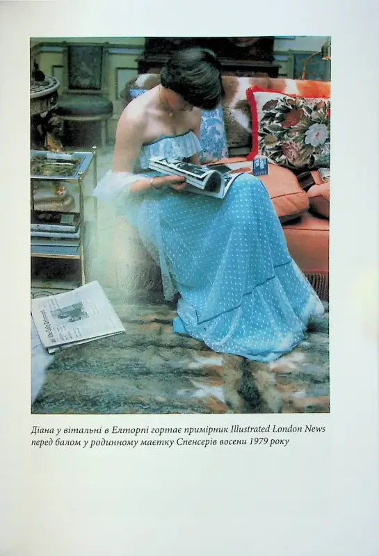 Woman in blue dress reading magazine.