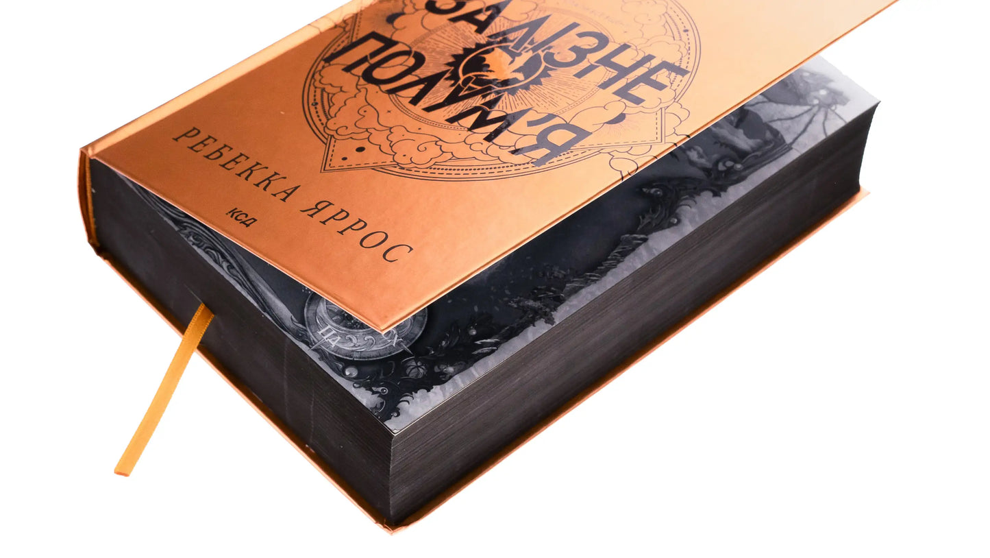 Gold-covered book with black edges and bookmark from Iron Flame, by Rebecca Yarros