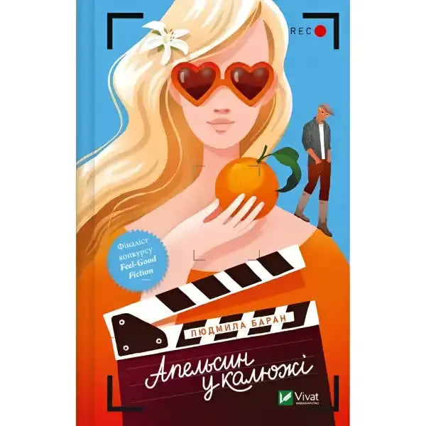 Book cover with a blonde woman holding an orange from the English books Orange in a Puddle Book cover with a blonde woman holding an orange from the English books Orange in a Puddle