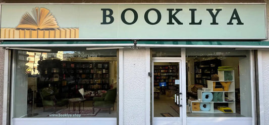 Elegant white and gold bookshelf with open Ukrainian books in Booklya, Ciudad Lineal