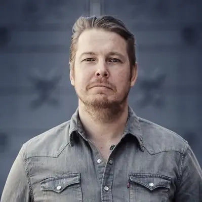 Man in gray denim shirt from Fredrik Backman collection featuring English books