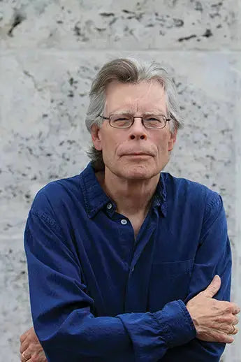 Portrait of Stephen King in a collection of bestselling thriller novels and books
