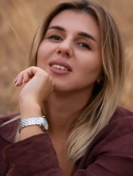 Woman with blonde hair in dark red top and silver watch at Marina Kiose poetry event
