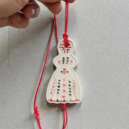Handmade ceramic Motanka doll amulet with red embroidered patterns