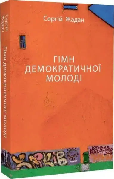 Orange hardcover of Hymn of Democratic Youth by Serhiy Zhadan on graffiti wall