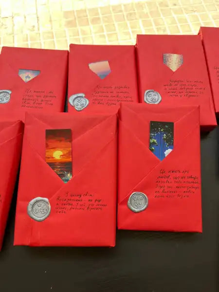 Red gift-wrapped packages with decorative seals for Mystery Wrapped Book RED edition