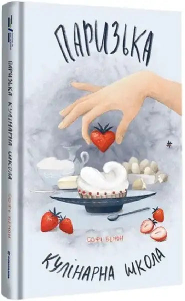 Paris Cooking School cookbook with a light blue cover, featuring a hand holding a heart-shaped strawberry above a cupcake and ingredients