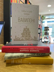 Stack of four books on financial literacy with the top book standing upright for achieving financial freedom