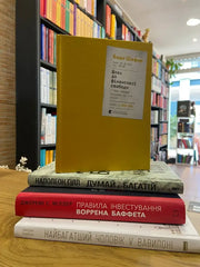Stack of four books on financial literacy with a yellow hardcover for achieving financial freedom