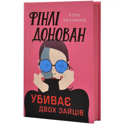 Pink book cover of Finlay Donovan Is Killing It by Elle Cosimano with a woman wearing blue glasses